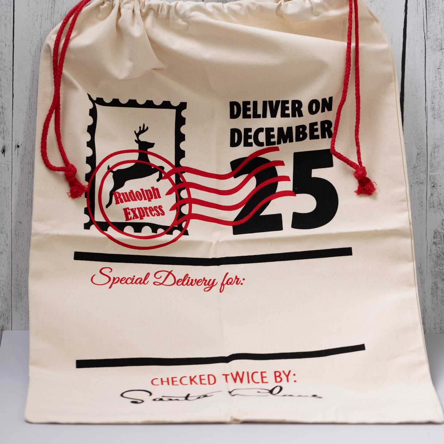Christmas Gift Bags | Reusable Oversized Fabric with Drawstring Cord - Deliver on December 25 Logo